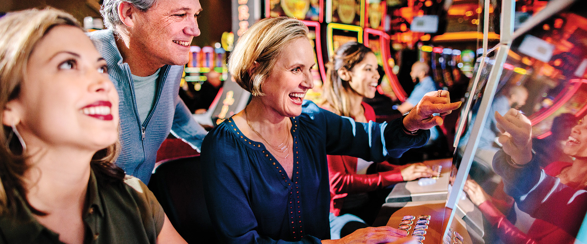 Row of guests playing slot machines.