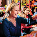 Row of guests playing slot machines.